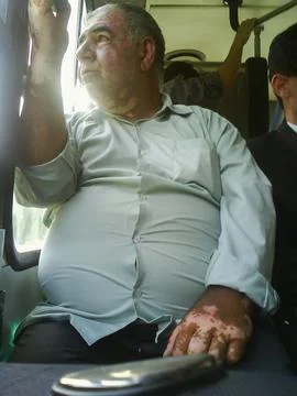 Middle-aged man sitting on a bus seat looking out the window Stock Photos