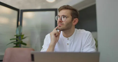 Middle aged man sitting at table in cafe,working on laptop computer and thinking Stock Footage 160770964