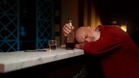 Middle-aged man sleeps on bar counter after binge drinking, alcohol addiction Stock Footage 342520349