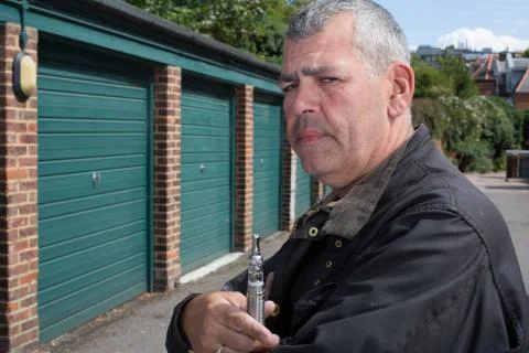 Middle-aged man smoking an e-cigarette Stock Photos