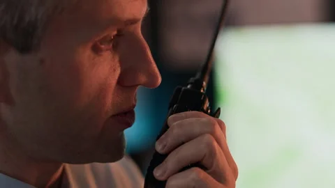 Middle-aged Man Speaking into Walkie-talkie in Command Center Stock Footage 343742642