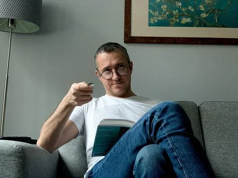 Middle aged man is spending holiday at home. Looked bored of streaming tv and Foto stock