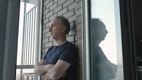 A middle-aged man stands on the veranda and thinks about his problems. Stock-Footage 99174759