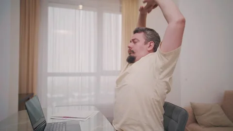 Middle aged man stretching at desk during home office break Stock Footage 340925041