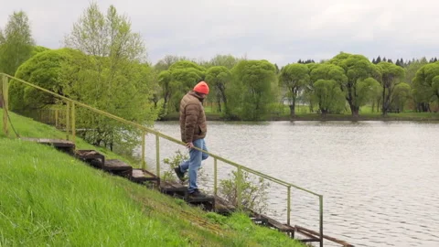 A middle-aged man strolling along the river road Stock Footage 274578778