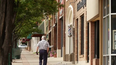 Middle aged man strolls main street Cedar City Vídeos de archivo 70215668