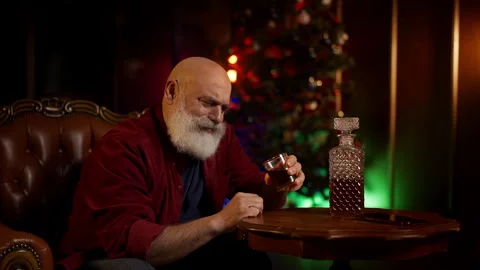 Middle-aged man struggles with Christmas loneliness while drinking alcohol alone Stock Footage 342520460