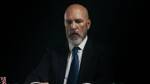 Middle-aged man in suit feeling nervous while raising poker bet, taking a risk Stock Footage 312329544