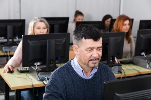 Middle aged man taking computer lessons Stockfoto's