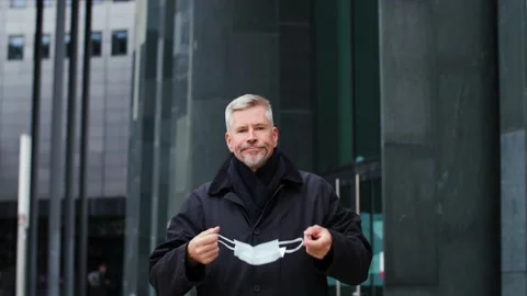 Middle aged man taking off face mask in the city and looking annoyedat camera. Stock Footage 165210138