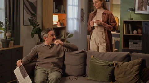 Middle Aged Man Taking Mug of Coffee from Wife at Home Video stock 338075467