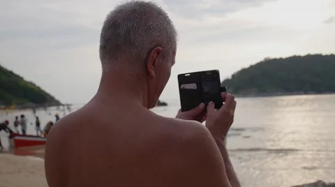 Middle-aged Man Taking Photo By Phone on Beach Vidéo 59158155