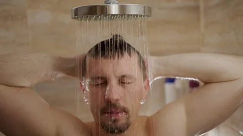 Middle-aged man taking a refreshing shower under rain shower head. A man wi.. Video stock 332162304
