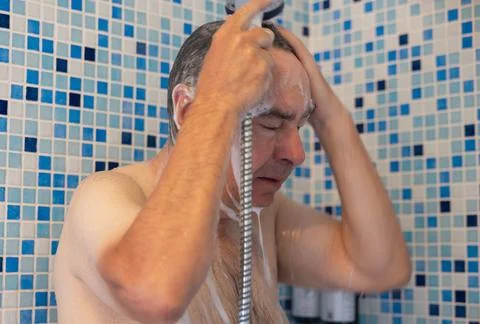 Middle-aged man taking a shower, shampooing hair. Stock Photos