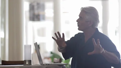 Middle-aged man talking by a laptop. 스톡 동영상 88371552