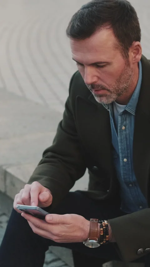 Middle aged man talking on mobile phone on old town background Stock Footage 227135449