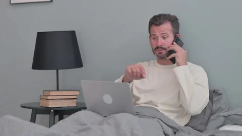 Middle Aged Man Talking on phone in Bed Video stock 287899134