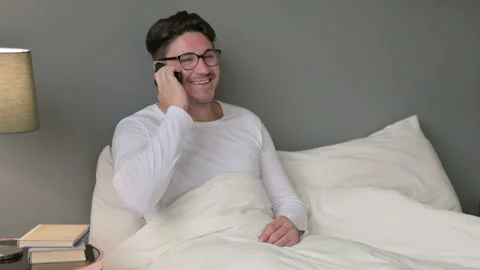 Middle Aged Man Talking on Smartphone in Bed 스톡 동영상 142371282