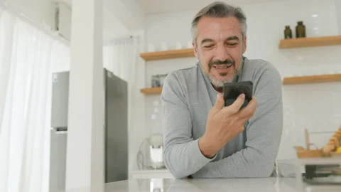 Middle aged man talking on a smartphone with a relaxed expression Stock Footage 293340948