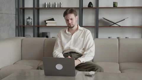 Middle Aged Man Thinking and Working on Laptop while Sitting on Couch Stock Footage 295185463