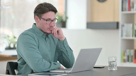 Middle Aged Man Thinking While working on Laptop Video stock 145759989