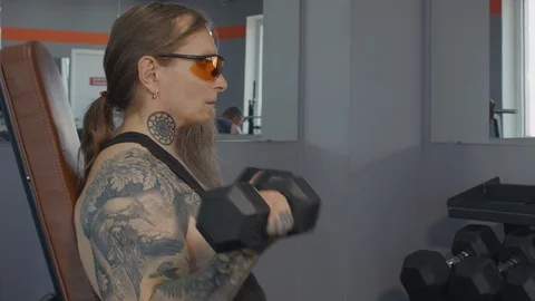 A middle-aged man trains biceps with dumbbells Stock Footage 115430184