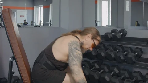 A middle-aged man trains biceps with dumbbells Stock Footage 115430327