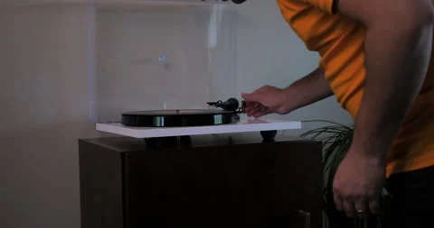 Middle-aged man turns on record player and drops needle. Stock Footage 140265281