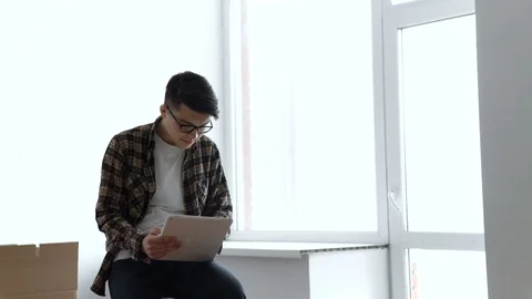 Middle-aged man using app on tablet after moving to new place Stock Footage 72880051