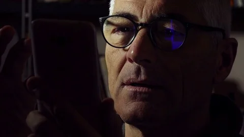 Middle aged man using cell phone in the night with reflection on glasses Stock-Footage 74430973