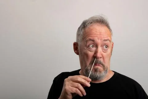 Middle aged man, using the coronavirus antigen rapid self-test, with a cotton Stock Photos