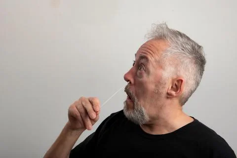 Middle aged man, using the coronavirus antigen rapid self-test, with a cotton Stock Photos