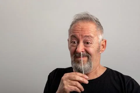 Middle aged man, using the coronavirus antigen rapid self-test, with a cotton Stock Photos