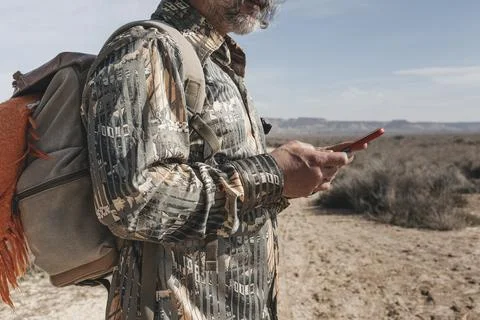 Middle-aged man using her smartphone on a day hike Stock Photos