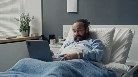 Middle Aged Man Using Laptop in Hospital Bed Stock Footage 347891390