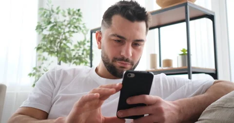 Middle aged man using smartphone on sofa Stock Footage 150017850