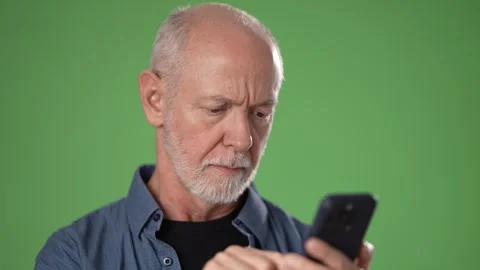 Middle-aged Man Using Smartphone in Front of Green Screen Backdrop Stock Footage 311117448