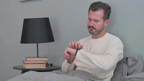 Middle Aged Man Using Smartwatch in Bed Stock Footage 287898875