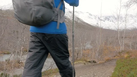 A middle-aged man walking along a mountain path with a backpack. He travels and Video stock 96914876