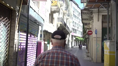 Middle aged man walking back and legs gimbal shot in Athens Stock Footage 167839908