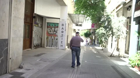 Middle aged man walking back gimbal shot in Athens Stock Footage 167840396