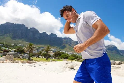 Middle aged man walking on the beach in summer Stock Photos