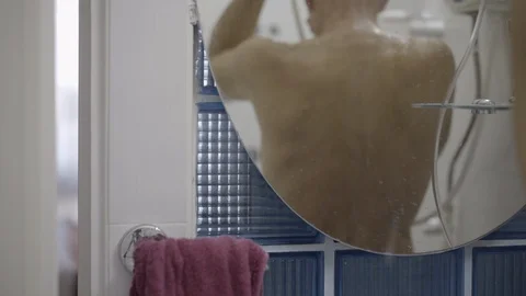 Middle-aged man washing under shower. person from behind. Stock Footage 121516901