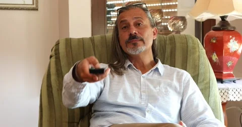 Middle aged man watching tv at home Stock Footage 141687853