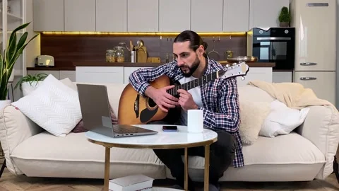 Middle aged man watching video tutorial to learn playing guitar indoor 스톡 동영상 227603649
