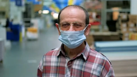 A middle-aged man is wearing a mask in a supermarket. The camera pulls back Stock Footage 147677798
