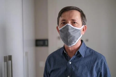 Middle-aged man wears face mask in the Coronavirus  Covid19 pandemic Stock Photos