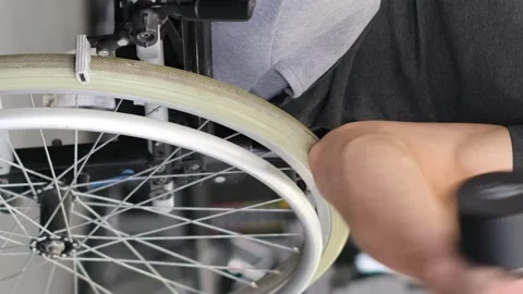 A middle-aged man in a wheelchair is working out in the gym. Vertical video Video stock 249760481