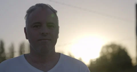Middle-aged man in a white T-shirt staring into camera with excitement in Sunset Video stock 156635962