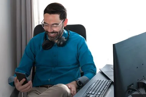 Middle-aged man. Work online. Laughing at the smartphone in Video call Stock Photos